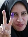 Iraqi woman shows purple finger indicating she voted in first competitive election in a half century