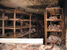 Photo: Storage room in basement of Revolutionary Command Council Headquarters. Burned frames of PC workstations visible on shelves.